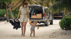 A heartwarming travel scene featuring a young mother and her toddler daughter exploring a tropical location, inspired by the minimalist travel lifestyle.