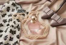 Subtle Elegance in Fashion: Lessons from Style Icons A stylish flat lay of timeless fashion items a little black dress, pearl necklace, designer perfume, and classic heels on a soft beige background, radiating subtle elegance and sophistication.