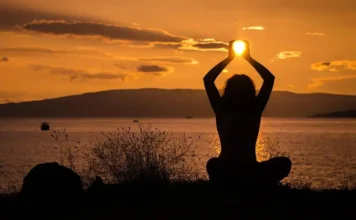 Holistic Well-Being: Your Path to a Balanced Life A serene nature scene with a woman meditating featuring Holistic Health & Well-Being