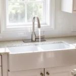 A modern farmhouse kitchen featuring a sleek American Standard farmhouse sink with a stainless steel faucet