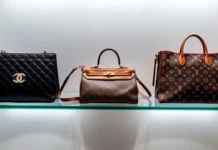 A luxurious display of iconic handbags, including Chanel, Hermès, and Louis Vuitton, arranged on a chic glass shelf with soft lighting and a stylish backdrop.