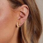25+ Stunning Small Gold Hoop Earrings for Every Style A pair of elegant small gold hoop earrings displayed on a white marble surface