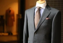 Suit Alterations Cost: Pricing Guide & Money-Saving Tips A well-dressed man in a tailor shop, having his suit measured by a professional tailor. featuring Suit Alterations Cost