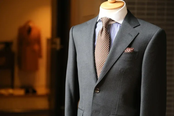 A well-dressed man in a tailor shop, having his suit measured by a professional tailor. featuring Suit Alterations Cost 