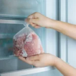 A modern compact fridge freezer in a cozy studio apartment