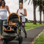 Jogging Stroller Pish Posh Baby: Premium Performance Guide Professional lifestyle photo of an athletic mother in premium activewear jogging through an upscale urban park with a sleek, modern Jogging Stroller Pish Posh Baby