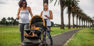 Professional lifestyle photo of an athletic mother in premium activewear jogging through an upscale urban park with a sleek, modern Jogging Stroller Pish Posh Baby