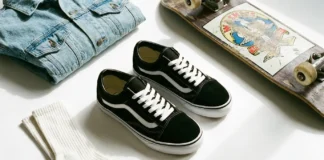 Black Vans Old Skool shoes styled with denim and skateboard accessories on white background