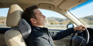 Aukee Memory Foam Car Neck Pillow Reviews: Is It Worth It? Driver using Aukee memory foam car neck pillow in a modern car seat during a comfortable road trip, showing ergonomic neck support and relaxed driving posture.
