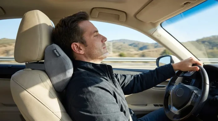 Driver using Aukee memory foam car neck pillow in a modern car seat during a comfortable road trip, showing ergonomic neck support and relaxed driving posture.