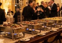 Professional stainless steel chafing dishes with burners keeping buffet food warm at a catering event