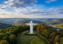 Christ of the Ozarks Statue Visitor Guide The Christ of the Ozarks statue standing atop Magnetic Mountain overlooking the forests of Eureka Springs, Arkansas.
