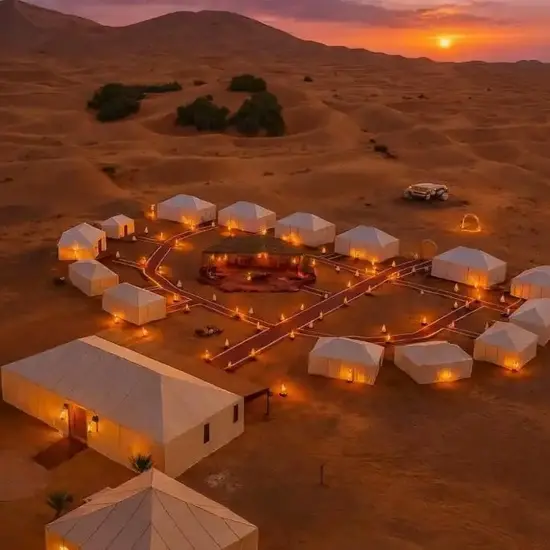 Luxury desert camp in Morocco surrounded by Sahara dunes at sunset