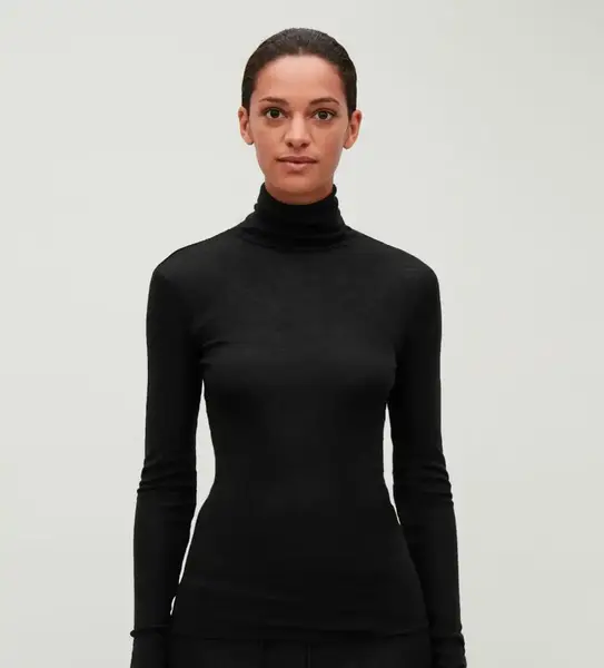 Black fine-knit turtleneck sweater designed for layering under tailored blazers and winter coats.
