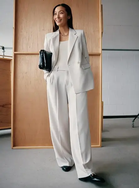 Cream wide-leg trousers in a substantial fabric for refined winter capsule wardrobe outfits.