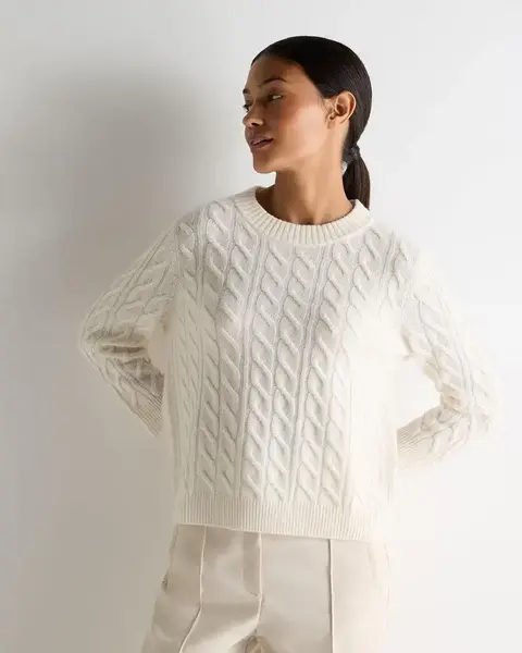 Ivory cable-knit sweater with textured detailing for a classic winter capsule wardrobe.